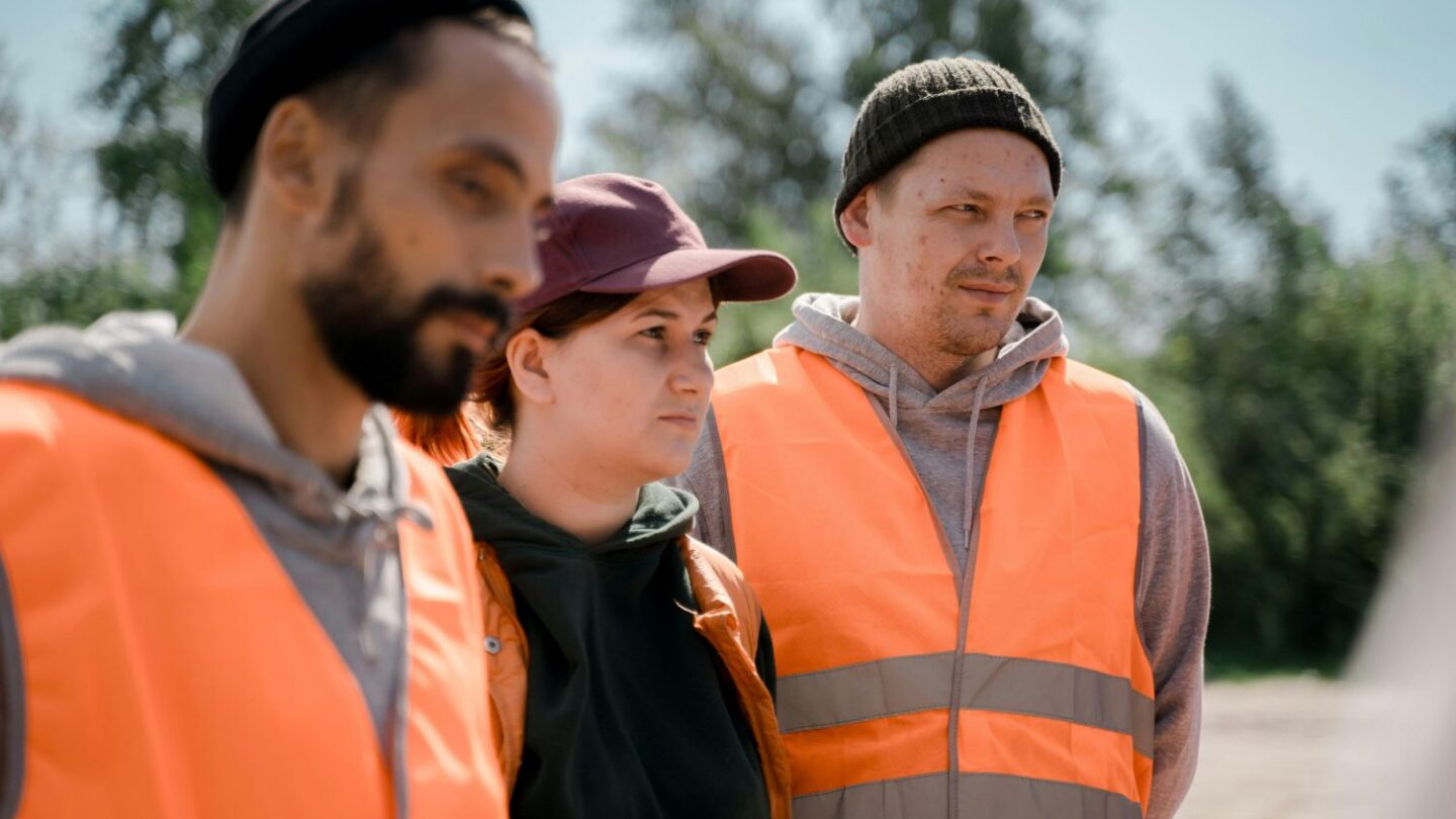 Tre bygningskonstruktørende iført orange vest