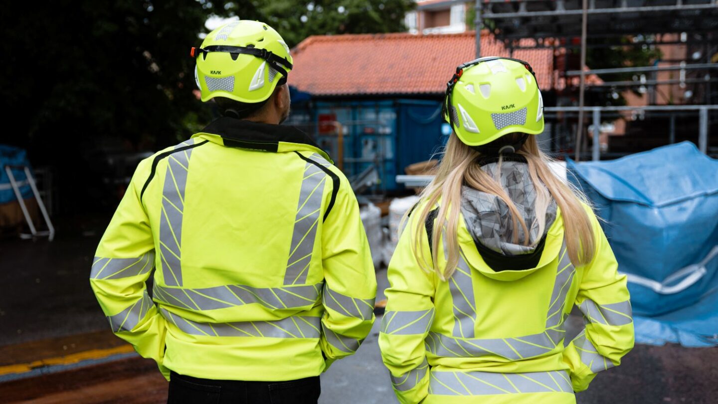To bygningskonstruktører iført gule veste og hjelm