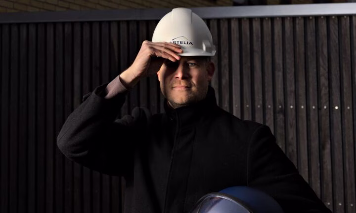 På billedet ses Jesper Bjeld, som er iført en hvid byggehjelm, mens han holder en kamphjelm. Jesper var nemlig i politiet i mange år, inden han blev bygningskonstruktør