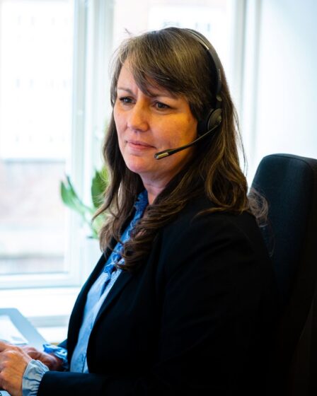 Medarbejder i Konstruktørforeningen iført headset.
